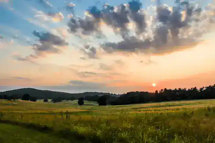 Pennsylvania meadow at sunset with rolling hills and warm sky